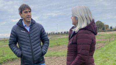 Man and woman standing next to each other on farmland